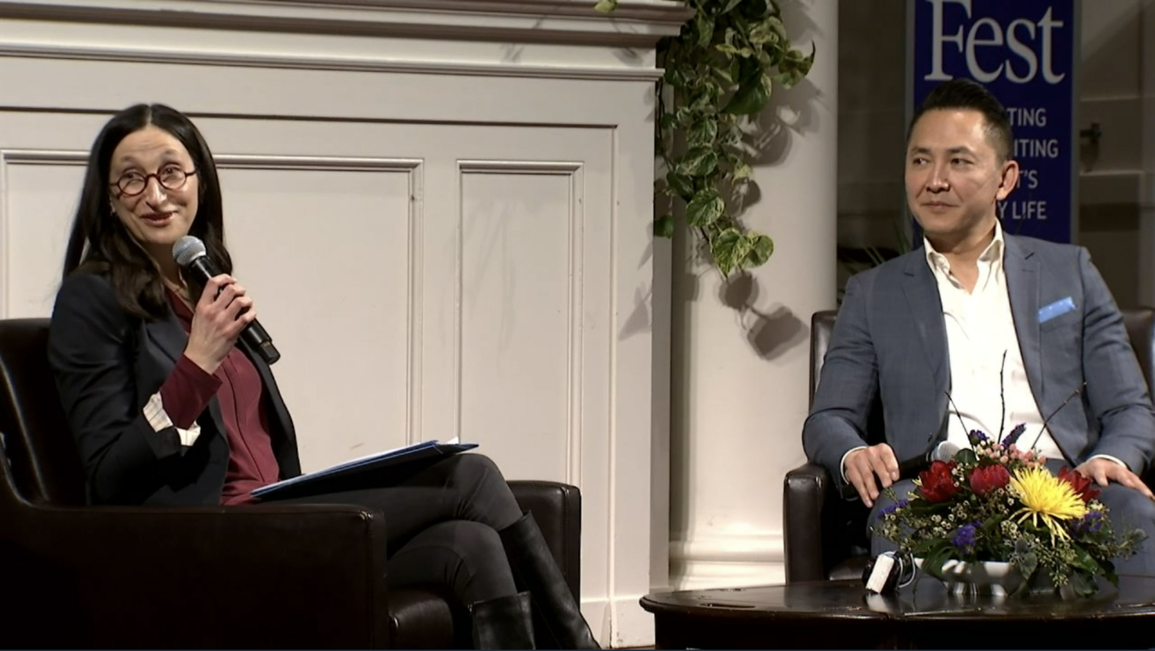 Photo depicts Viet Thanh Nguyen sitting in a chair, in conversation with the moderator of the event.