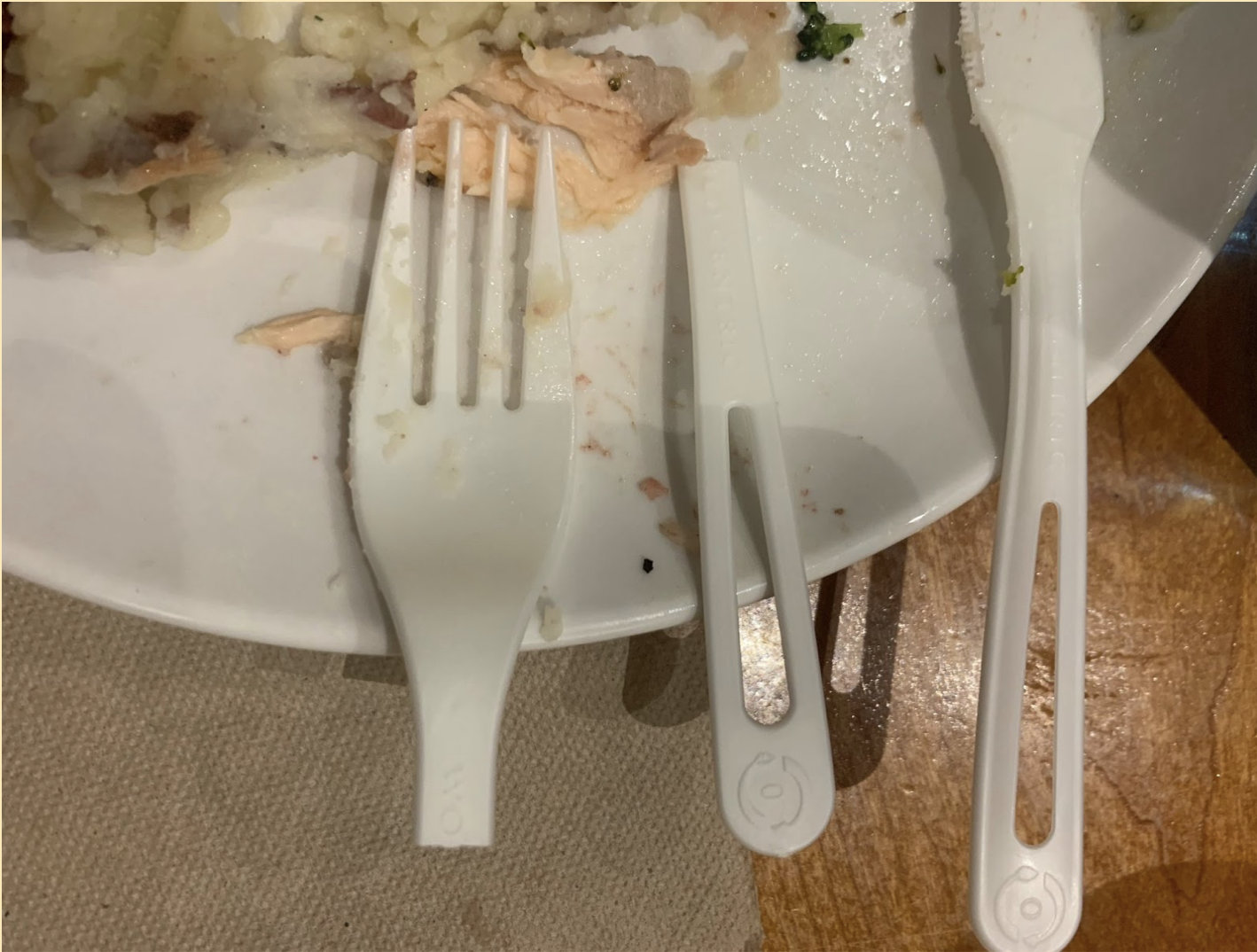 Compostable fork, snapped into three parts, on a plate.