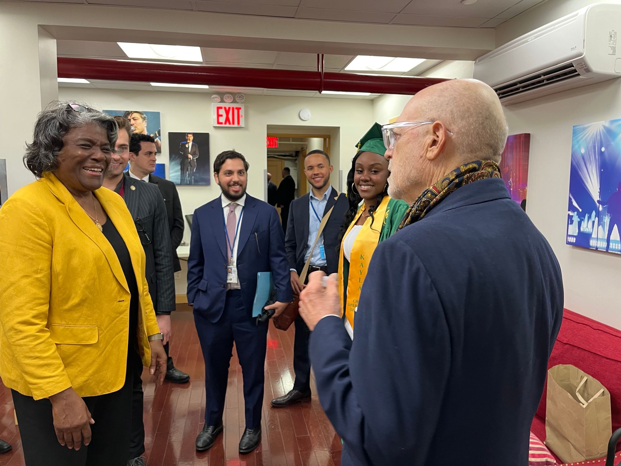 Pevsner smiling as Thompson-Greenfield socializes with high school graduates and staff at a commencement ceremony.