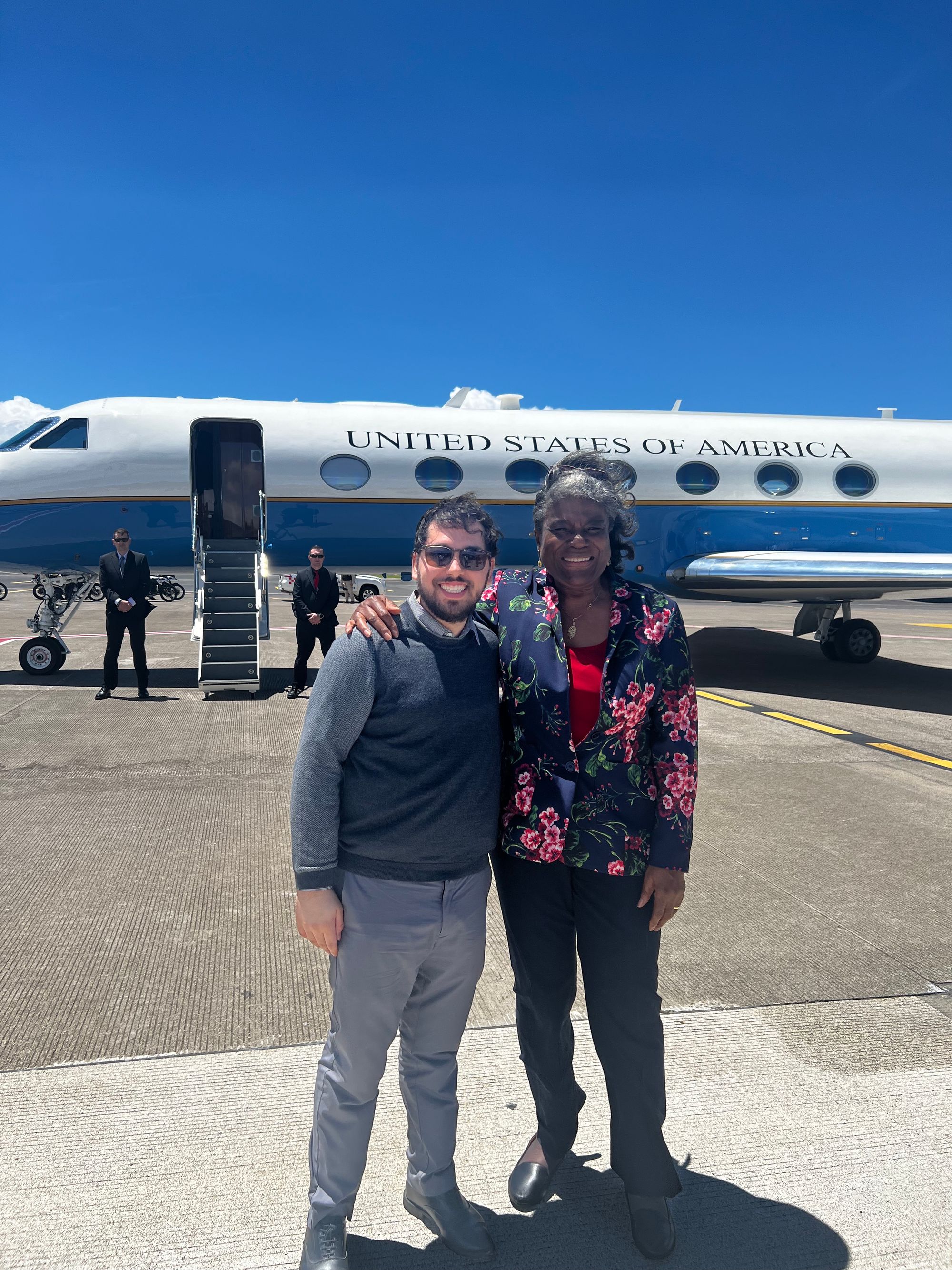 Pevsner with Thompson-Greenfield on the runway in front of a U.S. passenger jet.